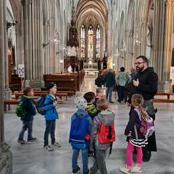 Pater Ulrich. zeigt den Kindern die Stiftskirche